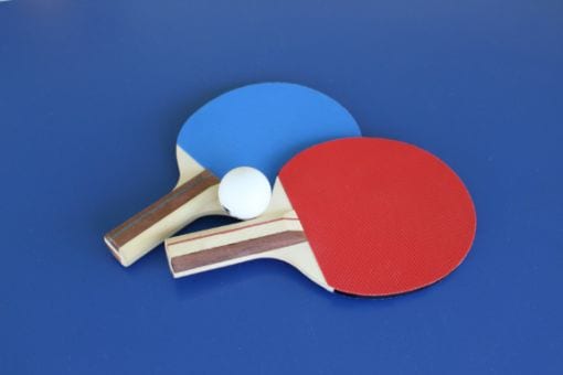 Two table tennis paddles with ball