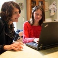 Teacher and pupil using laptop