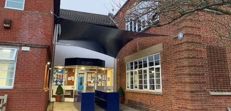 Wall-mounted sail shade we installed at Epsom College