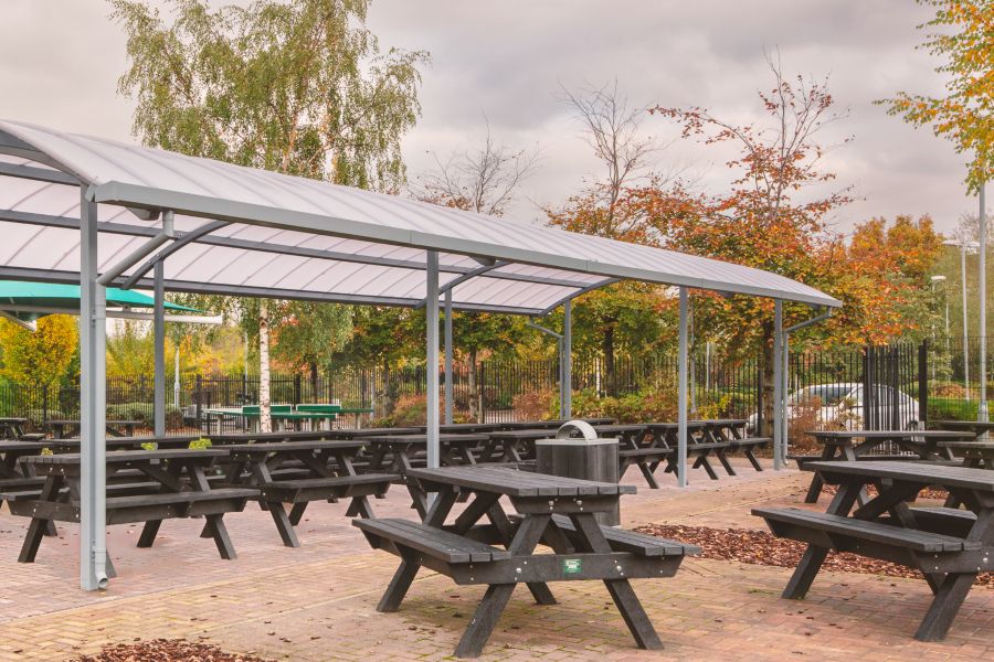Henry Benches sit under outdoor dining area canopy.