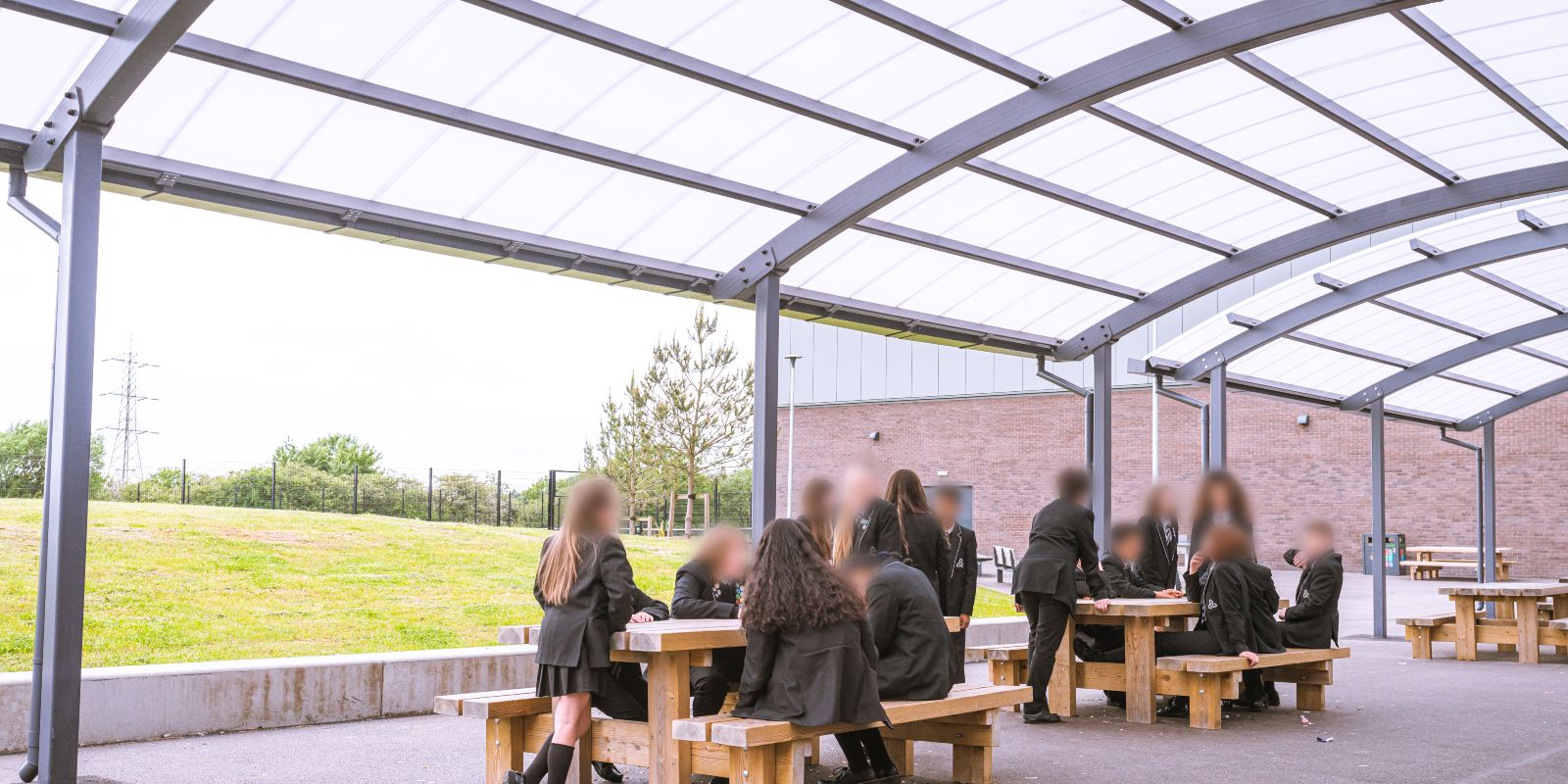 students eating outside under canopy